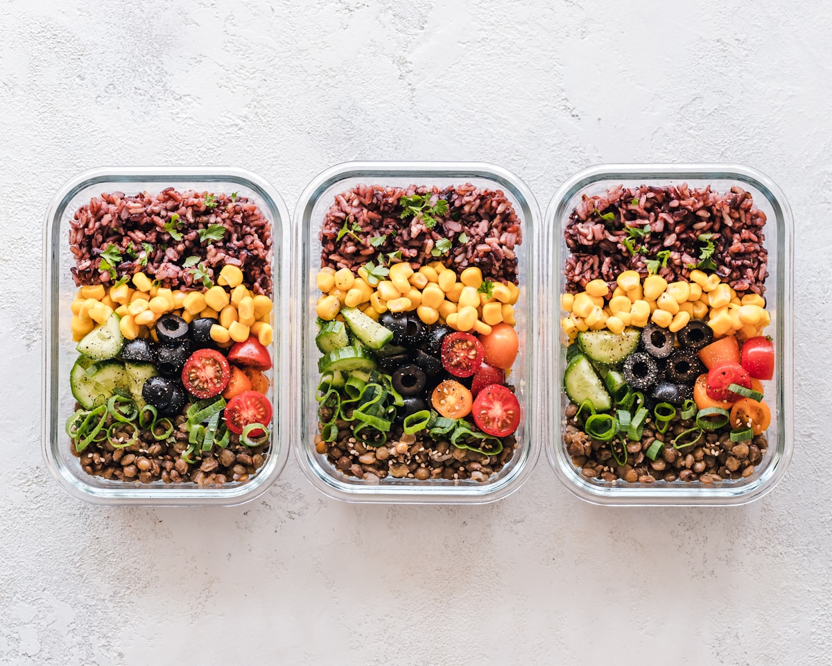 Embalagem para marmita: três marmitex com tampa montados com arroz, legumes e proteína